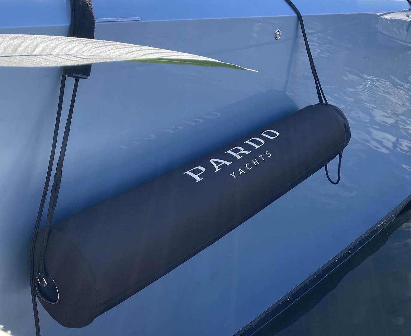 Pardo Yachts branded black neoprene FenderSox on blue hull waterside