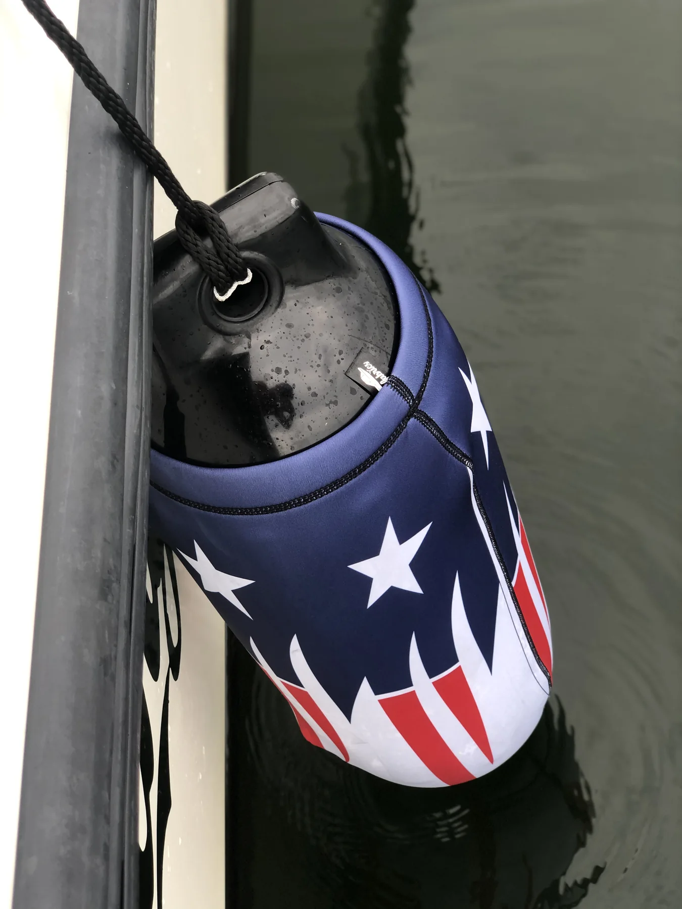 Patriotic star-and-stripe custom FenderSox protecting a boat hull at the dock