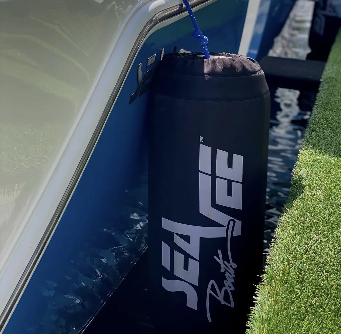 SeaVee branded black custom FenderSox hanging from a boat hull